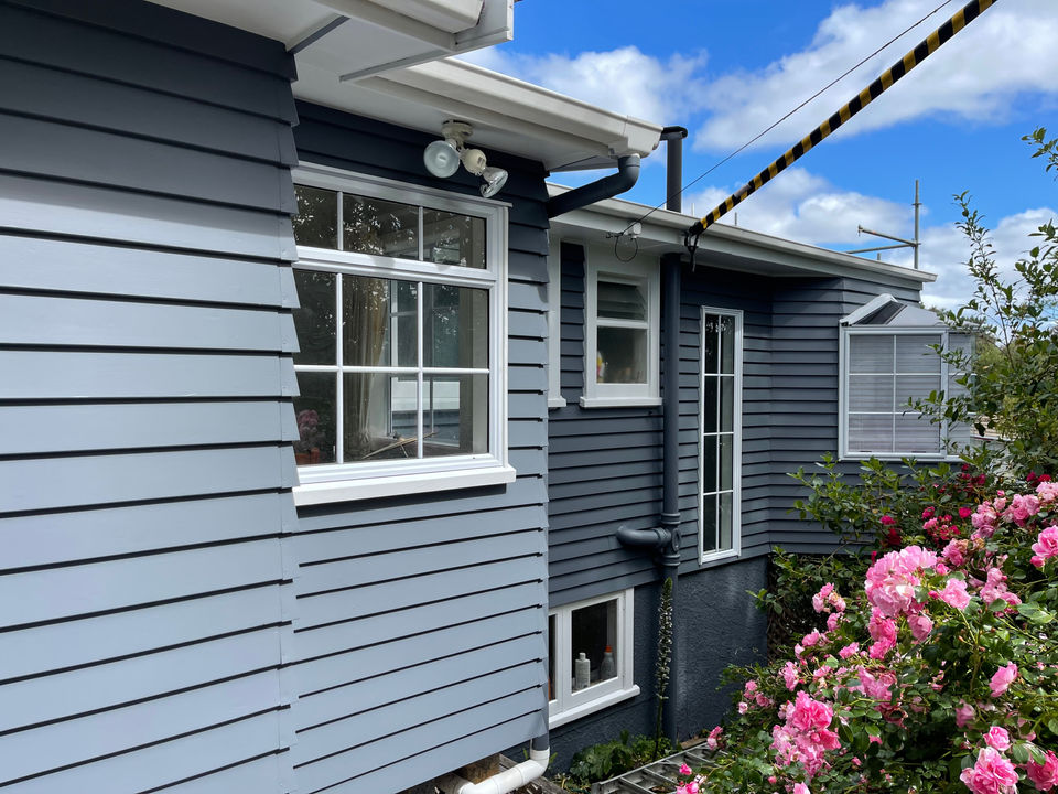 Grey weatherboard house with rose garden