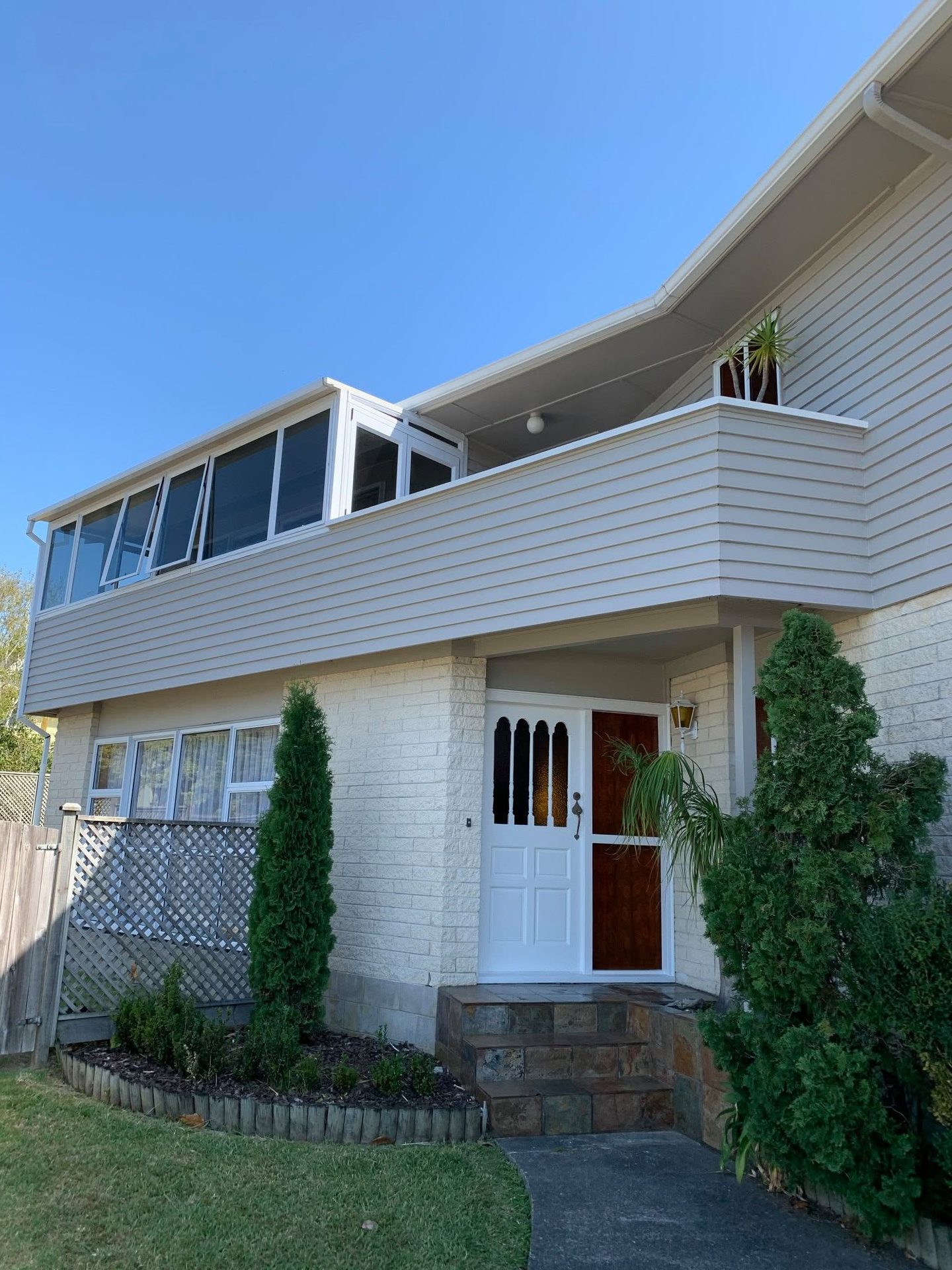Two-storey weatherboard home with crisp white trim